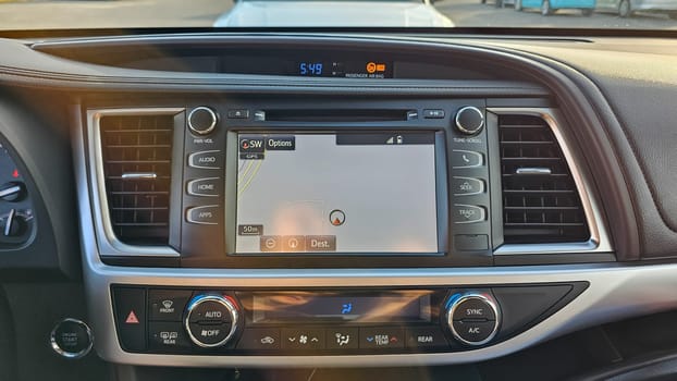 Daytime shot of a car s interior showcasing the dashboard with a navigation system display. Modern vehicle technology highlights convenience and connectivity for drivers.