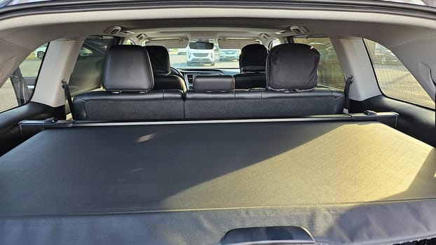 A view of a car s interior, highlighting the spacious trunk area with an extended cargo cover for storage. The rear seats provide comfortable seating for passengers during travel.