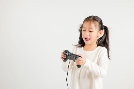 Asian happy portrait young kid girl smile lifestyle games technology holding joystick game playing on hands studio shot isolated white background with copy space, kindergarten child relaxation time