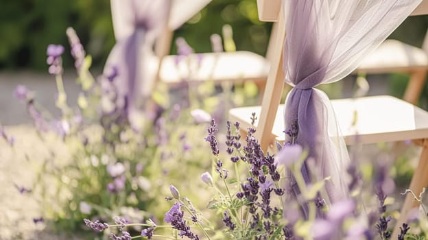 Aisle with wooden chairs and purple lavender floral decorations at an outdoor wedding ceremony in the garden