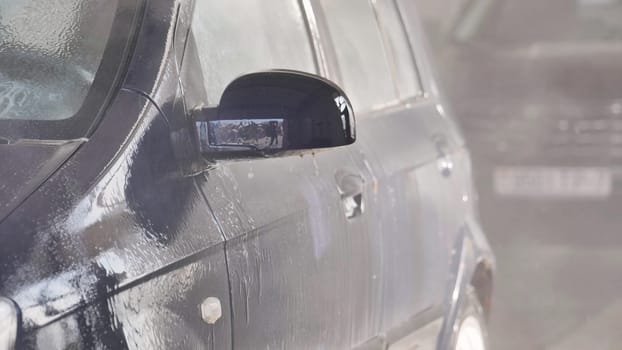 Car is being washed with soap in a car wash