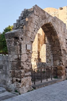 Architectural remnants of a venerable church featuring impressive stone arches, bathed in warm sunlight, evoking a sense of ancient history and enduring beauty in the Greek landscape.