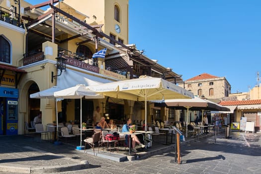 Rodas.Greece - may 22, 2025: This vibrant al fresco dining area in a historic Greek city, featuring charming tables and chairs, invites patrons to enjoy local cuisine and drinks amidst the picturesque old town ambiance.
