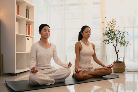 Peaceful mother and daughter practice mindfulness and meditation together.