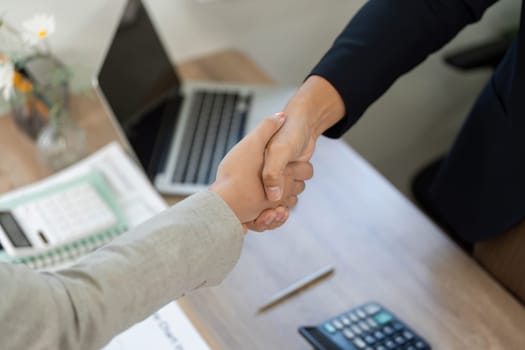A close-up of a handshake between business partners, symbolizing agreement and collaboration in a corporate setting.