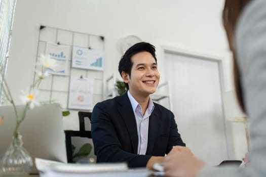 A business consultant smiling and engaging in conversation with a client, fostering a friendly and professional atmosphere.