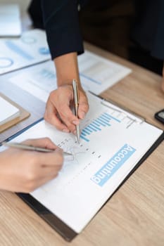 Hands of professionals analyzing financial data and making notes during a business consultation, focusing on accuracy.