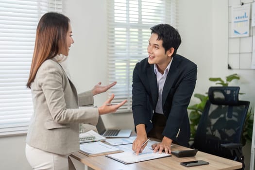 Two business professionals engaging in a lively discussion about project strategies and ideas in a modern office environment.