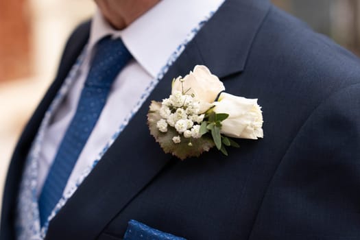 Groom with a boutonniere of white gypsophila and rose