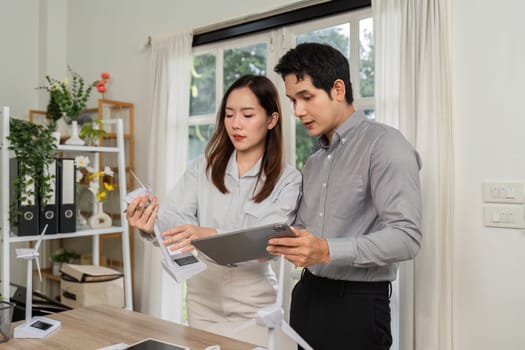 A businesswoman and her colleague review ESG metrics and sustainability data in a collaborative meeting environment.