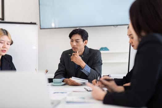 A team of professionals engages in a strategic planning session, analyzing project details and discussing actionable insights for better outcomes.