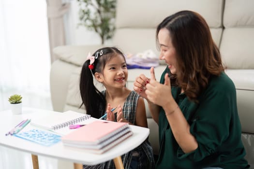 A cheerful moment shared between a mother and daughter as they engage in creative activities, preparing for school.