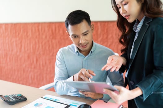 Two business colleagues reviewing analytics on a tablet, showcasing teamwork and digital transformation in a professional setting.