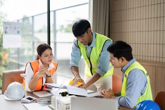 A diverse team of engineers engages in a strategic meeting focused on developing green technology initiatives, promoting teamwork and sustainability.