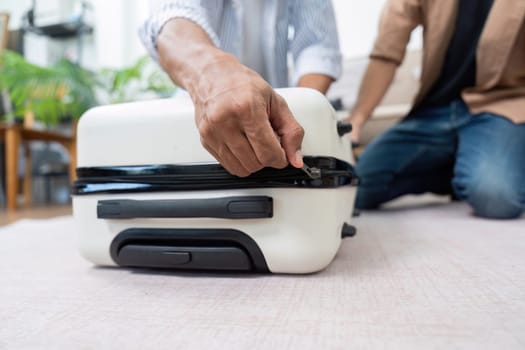 The couple is focused on packing their suitcase, highlighting their teamwork and shared enthusiasm for their travel plans.