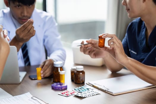 Doctors and nurses engage in a focused discussion about medication management strategies during a team meeting, emphasizing patient safety and effective treatment.
