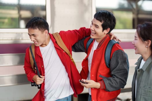 Two friends share a delightful moment, enjoying each others' company with a spirit of joy and anticipation before boarding their train.