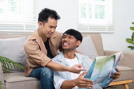 Two partners sit together on a cozy sofa, excitedly discussing their travel plans while examining a detailed map, showcasing their connection and shared dreams.