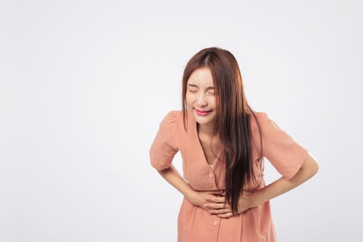 Stomach discomfort and stomach ache portrayed by a woman showing signs of period pain and internal cramp in a medical health concept isolated on studio white background