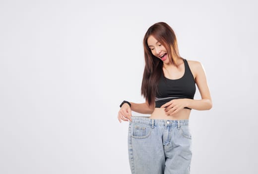 Weight change made her pants loose and her smile brighter. Her new shape proves that managing weight can lead to big happiness. isolated studio white background