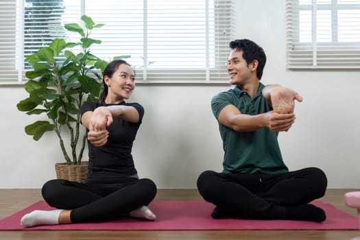 A couple enjoying stretching exercises together, fostering wellness and emotional connection in a serene home setting.
