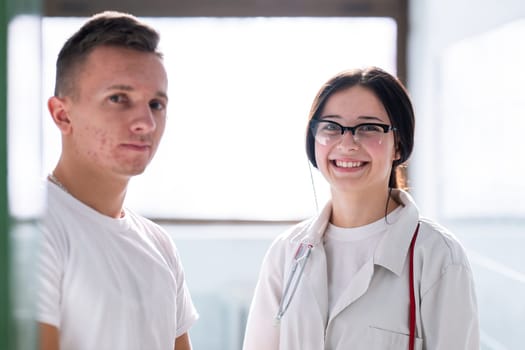 Male and female medical professionals smiling and standing together in a hospital hallway. Concept of teamwork and care