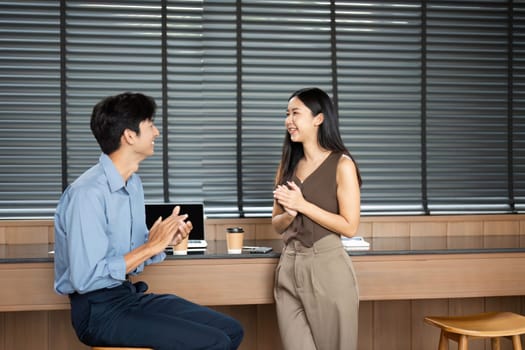 A joyful moment between colleagues in a contemporary workspace, showcasing teamwork and positive energy.