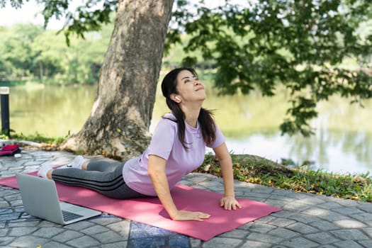 A woman enjoys yoga poses on a mat by the lakeside, enhancing wellness and tranquility in a peaceful environment.