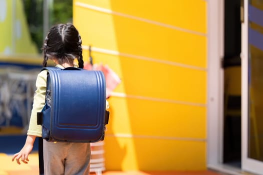 A child walks towards school, showcasing independence and excitement for the new school year.