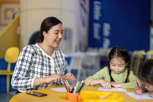 A teacher shares a joyful moment with her students as they engage in a fun learning activity, celebrating the back-to-school spirit.