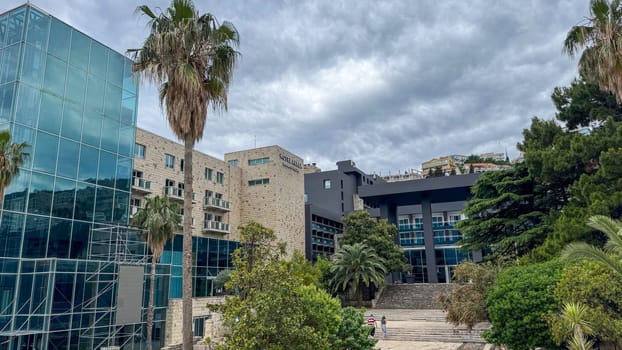 Budva, Montenegro - May 21, 2025: AVALA Hotel showcases modern architecture surrounded by lush greenery and palm trees