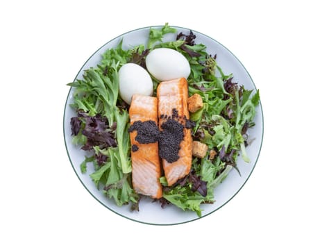 Top view of Homemade salad with Grilled salmon fillets, Boiled egg and Croutons topping Caviar on plate isolated on white background with clipping path, Simple yet very tasty dish.