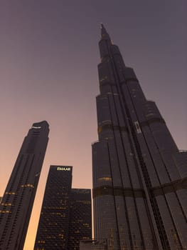 UAE, Dubai, 26 September 2024: The famous shopping center Dubai Mall and Burj Khalifa skyscraper at dusk, Dubai's sights and skyscrapers illuminated at night, palm trees. High quality photo