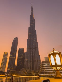 UAE, Dubai, 26 September 2024: The famous shopping center Dubai Mall and Burj Khalifa skyscraper at dusk, Dubai's sights and skyscrapers illuminated at night, palm trees. High quality photo