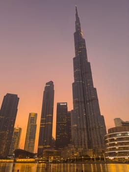 UAE, Dubai, 26 September 2024: The famous shopping center Dubai Mall and Burj Khalifa skyscraper at dusk, Dubai's sights and skyscrapers illuminated at night, palm trees. High quality photo