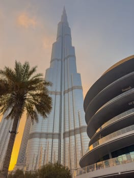UAE, Dubai, 26 September 2024: The famous shopping center Dubai Mall and Burj Khalifa skyscraper at dusk, Dubai's sights and skyscrapers illuminated at night, palm trees. High quality photo