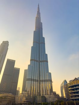 UAE, Dubai, 26 September 2024: The famous shopping center Dubai Mall and Burj Khalifa skyscraper at dusk, Dubai's sights and skyscrapers illuminated at night, palm trees. High quality photo