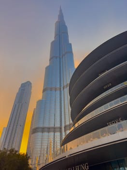UAE, Dubai, 26 September 2024: The famous shopping center Dubai Mall and Burj Khalifa skyscraper at dusk, Dubai's sights and skyscrapers illuminated at night, palm trees. High quality photo
