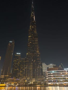 UAE, Dubai, 26 September 2024: The famous shopping center Dubai Mall and Burj Khalifa skyscraper at dusk, Dubai's sights and skyscrapers illuminated at night, palm trees. High quality photo