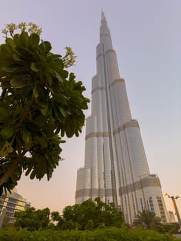 UAE, Dubai, 26 September 2024: The famous shopping center Dubai Mall and Burj Khalifa skyscraper at dusk, Dubai's sights and skyscrapers illuminated at night, palm trees. High quality photo