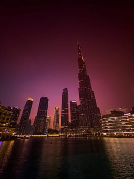 UAE, Dubai, 26 September 2024: The famous shopping center Dubai Mall and Burj Khalifa skyscraper at dusk, Dubai's sights and skyscrapers illuminated at night, palm trees. High quality photo
