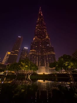 UAE, Dubai, 26 September 2024: The famous shopping center Dubai Mall and Burj Khalifa skyscraper at dusk, Dubai's sights and skyscrapers illuminated at night, palm trees. High quality photo
