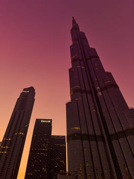 UAE, Dubai, 26 September 2024: The famous shopping center Dubai Mall and Burj Khalifa skyscraper at dusk, Dubai's sights and skyscrapers illuminated at night, palm trees. High quality photo
