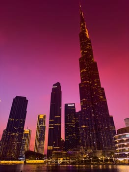 UAE, Dubai, 26 September 2024: The famous shopping center Dubai Mall and Burj Khalifa skyscraper at dusk, Dubai's sights and skyscrapers illuminated at night, palm trees. High quality photo