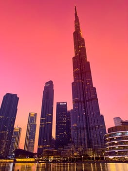 UAE, Dubai, 26 September 2024: The famous shopping center Dubai Mall and Burj Khalifa skyscraper at dusk, Dubai's sights and skyscrapers illuminated at night, palm trees. High quality photo