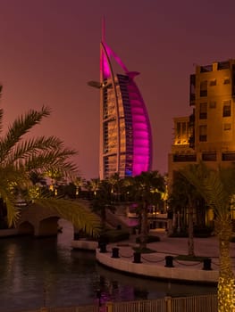 UAE, Dubai, 23 September 2024: night illumination of luxury hotel The Burj Al Arab Jumeirah Resort is located on its own island, with suites overlooking the sea, restaurants and a spa, embankment. High quality photo