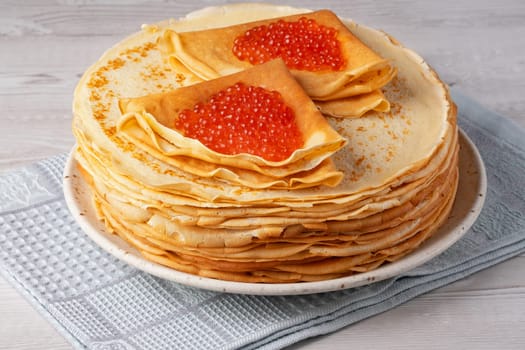 Freshly baked pancakes with red caviar..