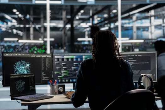 Data center worker using AI deep learning algorithms to analyze large datasets. Server farm technician using artificial intelligence and visual programming to recognize patterns in facility data