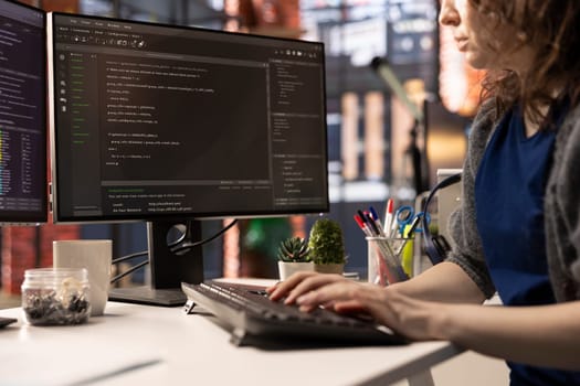 Professional software developer types code on a laptop in a sleek workspace. Expert IT freelancer doing remote work on app development, software engineering and agile coding practices.
