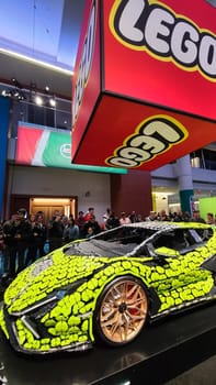 Toronto, ON Canada - 02.19.2023: Crowd Enthralled by Large Scale Lego Vehicle Model at Automotive Exhibition.